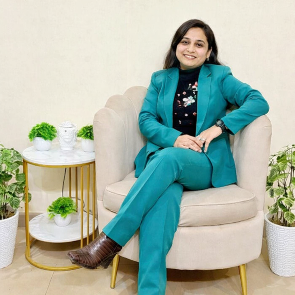 dr preeti maharaj Indian psychiatrist sitting in chair professional portrait teal suit mental health expert India